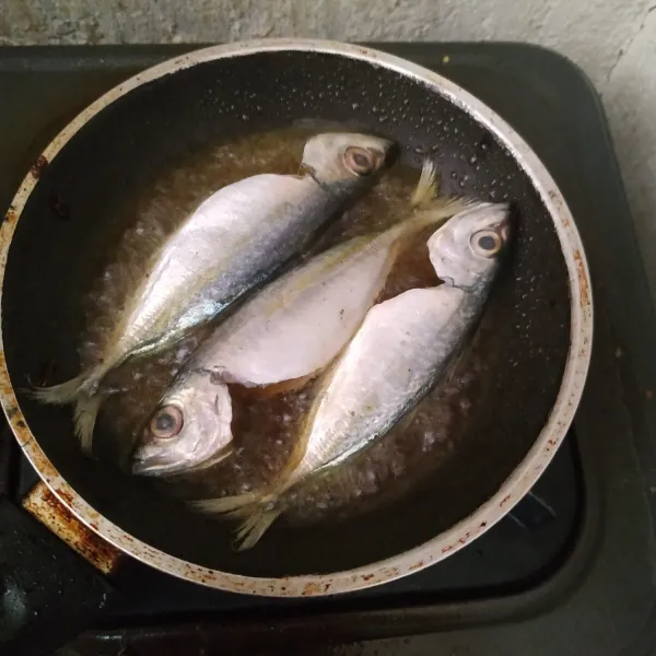 Panaskan minyak goreng. Goreng ikan kembung sampai matang. Lalu potong ikan menjadi masing-masing 2 bagian, lalu belah dan buang tulangnya