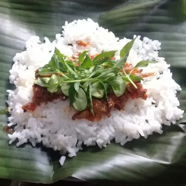 Tata sambal teri, petai dan daun kemangi di atas nasi