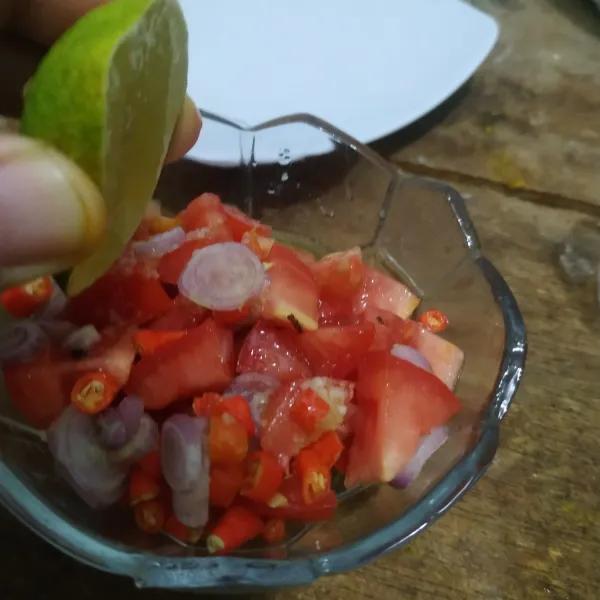 Masukkan irisan bawang, cabai dan tomat ke dalam wadah. Beri garam, minyak panas dan jeruk nipis. Aduk rata dan koreksi rasa