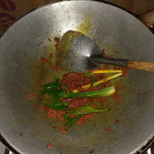 Tumis bumbu halus. Masukkan 1 lembar daun pandan, 1 lembar daun jeruk, dan 1 batang serai. Tumis hingga harum dan bumbu matang