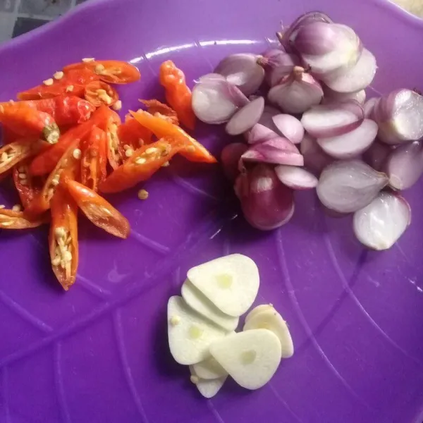 Potong tebal bawang merah, iris bawang putih dan cabai rawit orange, sisihkan