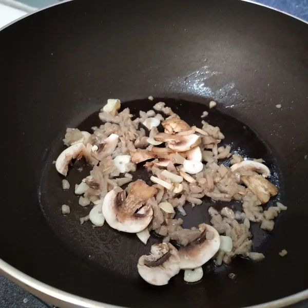 Tumis bawang putih hingga layu dan harum, kemudian masukkan udang cincang dan jamur. Masak hingga udang berubah warna