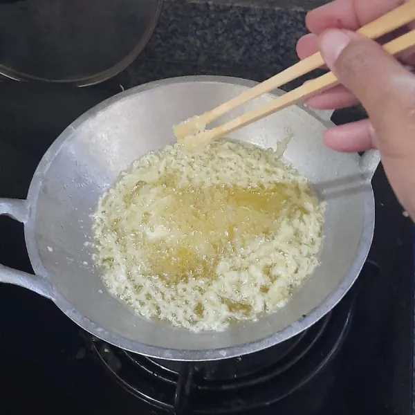 Panaskan minyak yang banyak. Percikkan adonan pelapis kedalamnya dan masak hingga membentuk remah berwarna kuning keemasan. Angkat dan tiriskan. Sisakan adonan pelapis untuk melumuri udang