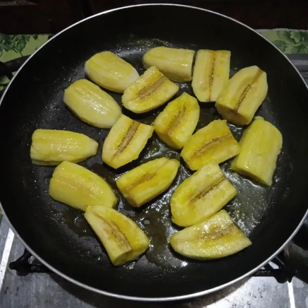 Belah masing-masing pisang menjadi empat bagian lalu panaskan margarin dalam wajan dan goreng pisang hingga sedikit kecoklatan. Angkat dan sisihkan terlebih dahulu.