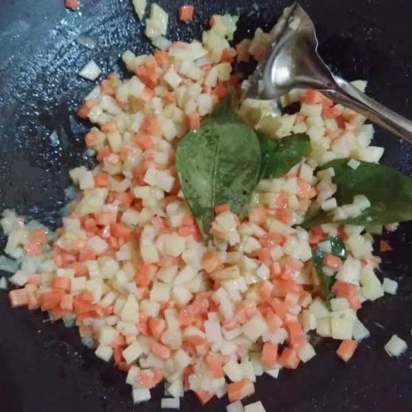 Masukkan potongan kentang, wortel, daun jeruk, dan daun salam.