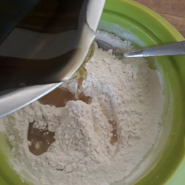 Tuangkan air rebusan pandan ke dalam adonan tepung. Aduk- aduk sampai tepung larut.