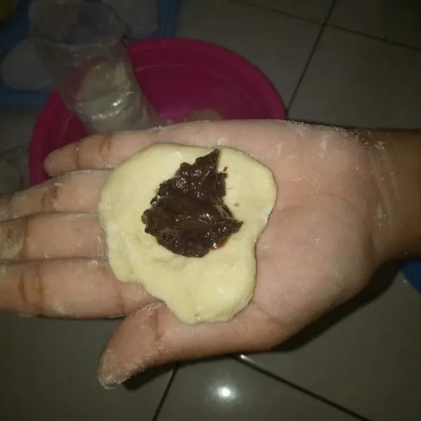 Bagi adonan masing-masing 35 gr atau sesuai selera. Berikan isian selai coklat lalu bentuk bulat adonan sehingga menutupi bahan isian.