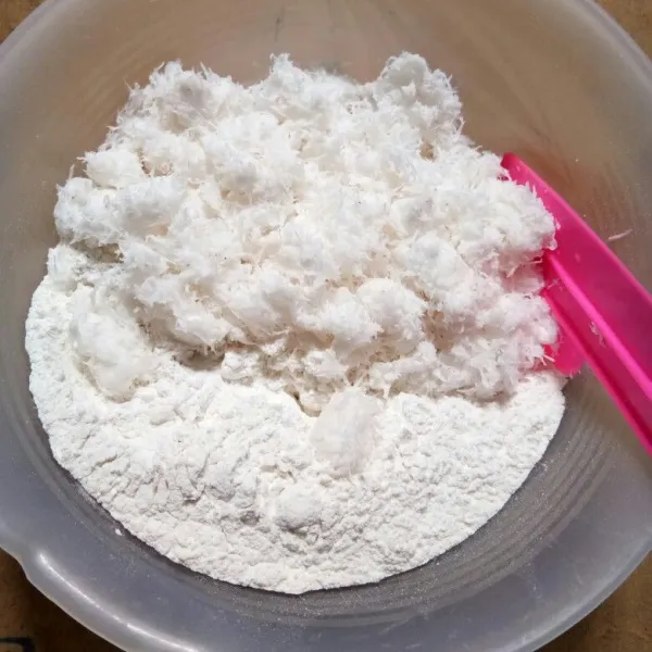 Campurkan tepung beras, kelapa parut, dan garam di dalam wadah kemudian aduk hingga rata.
