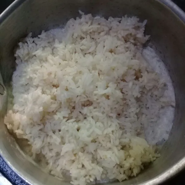 Masukkan beras ketan yang sudah dikukus tadi, aduk merata sampai santan meresap.