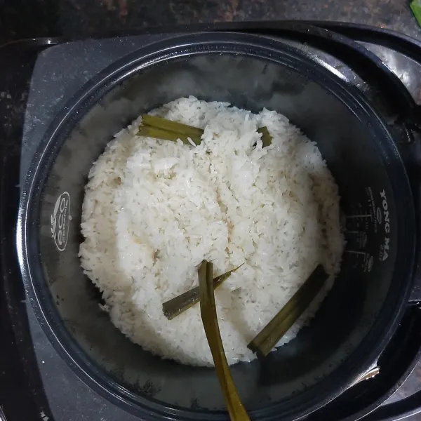 Masak beras ketan dalam rice cooker dengan daun pandan.