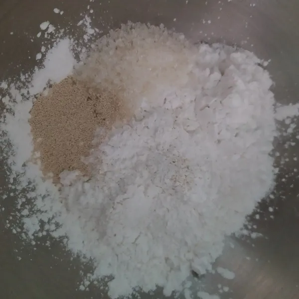 Satukan tepung beras, sagu, gula, dan ragi, dalam satu wadah kemudian aduk hingga rata.