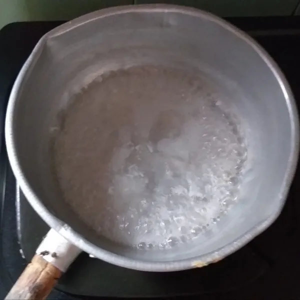 Membuat adonan biang: panaskan air di dalam panci, setelah itu masukkan tepung tapioka, dan aduk hingga mengental.