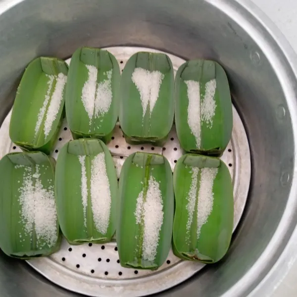 Siapkan daun pandan sebagai tempat kuenya. Siapkan dandang/panci berisi air lalu tambahkan 1 sdt gula.