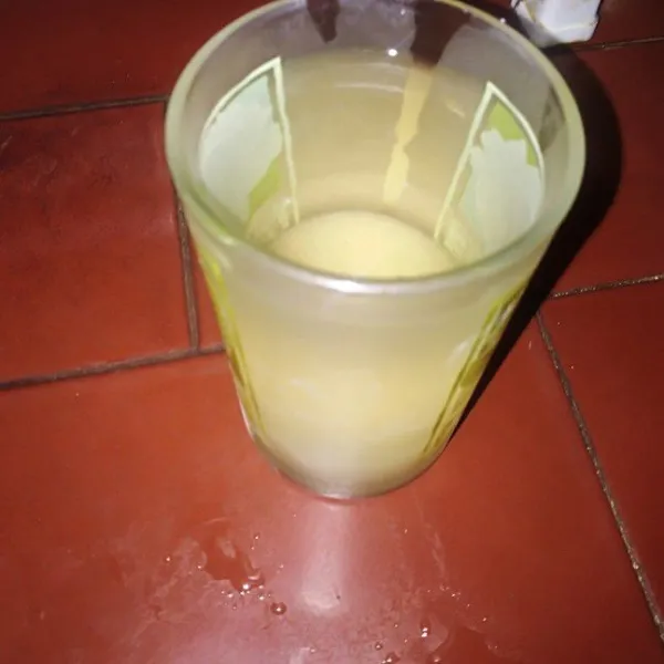 Campur gula dan air hangat, aduk hingga rata.