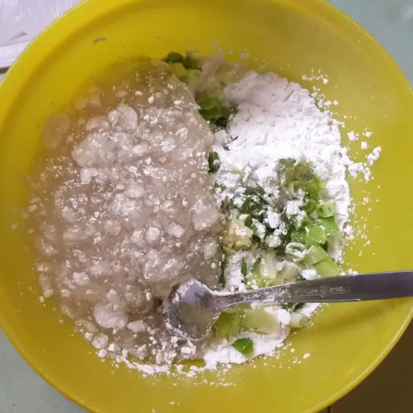 Masukkan bahan biang sesaat setelah diangkat dari panci, kemudian masukkan sisa tepung tapioka, dan bumbu-bumbu. Aduk hingga kalis.