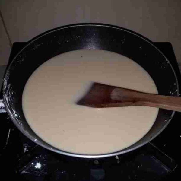 Siapkan teflon, masukkan tepung tapioka dan air. Aduk hingga tercampur rata dan tambahkan air gula merah, aduk. Nyalakan api kecil, aduk adonan hingga mengental.