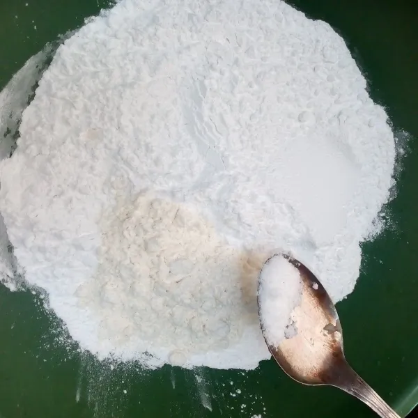 Siapkan wadah dan masukkan 2 ons tepung beras, 2 sdm tepung terigu, dan 1/4 sdm garam.