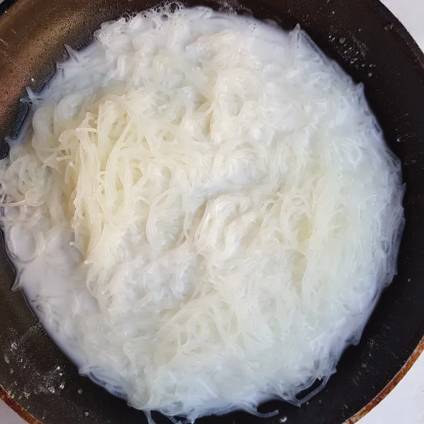 Siapkan teflon kemudian masukkan bihun jagung yang sudah direndam, tepung beras, air, dan garam. Aduk rata dan masak hingga air menyusut.