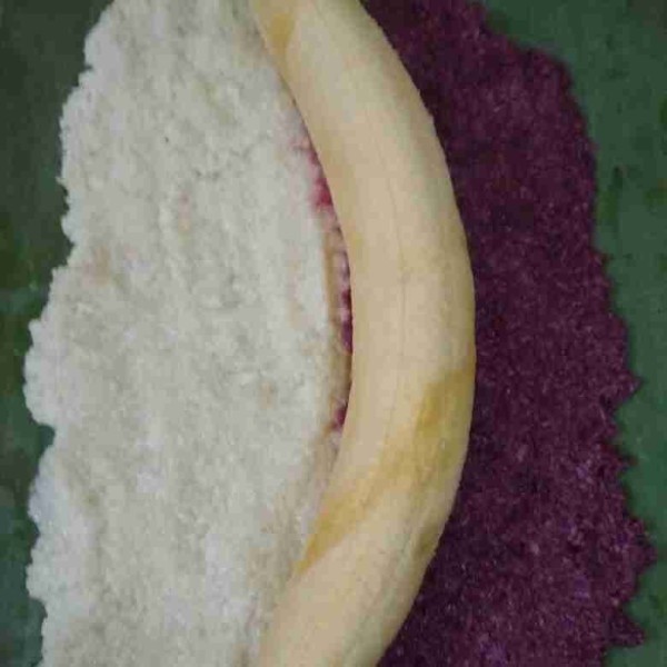 Letakan daun pisang, beri adonan red velvet berdampingan dengan adonan putih, pipihkan. Letakkan pisang tanduk di bagian tengah gulung dan ikat.