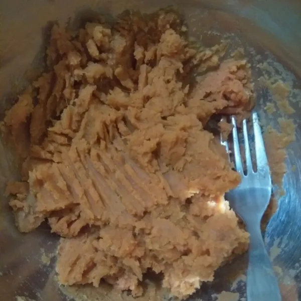 Haluskan ubi kuning dengan garpu kemudian masukkan gula halus dan vanili bubuk, aduk hingga rata.