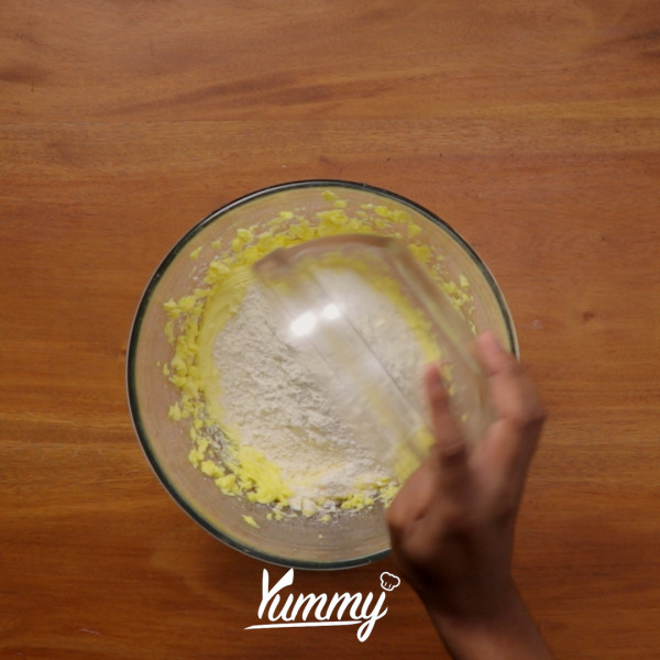 Tambahkan tepung terigu, keju edam dan baking powder lalu aduk hingga tercampur rata dengan menggunakan rubber spatula.