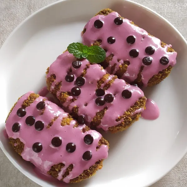 Panaskan minyak cukup banyak, goreng nugget pisang sampai kuning keemasan, tiriskan, biarkan hangat lalu beri topping glaze dan chocochip, siap disajikan.