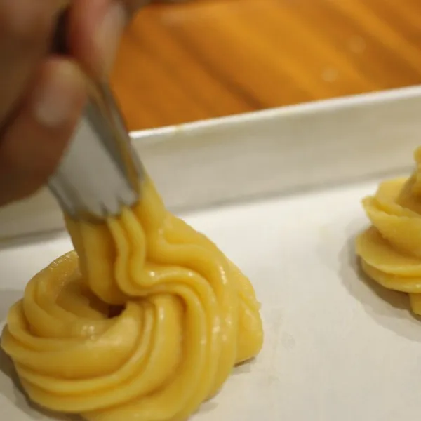 Bentuk adonan diatas loyang yang telah dioles dengan margarin dan tepung.