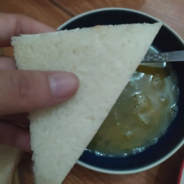 Potong dua roti tawar sehingga membentuk segitiga.