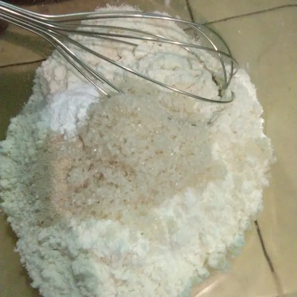 Campur bahan kering jadi satu, aduk rata tepung terigu, gula pasir, ragi instan, dan baking powder.