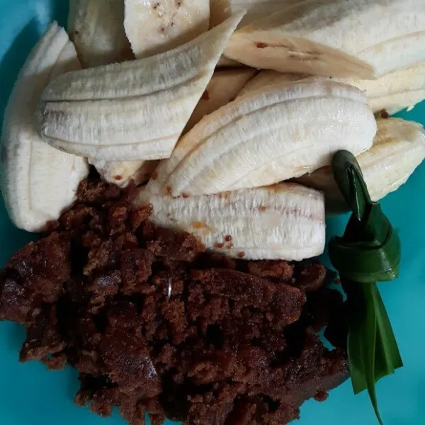 Potong 2 bagian masing-masing pisang. Sisir halus gula merah, simpulkan daun pandan.