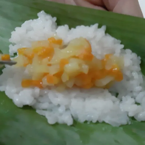 Siapkan daun pisang, lalu taruh beras yang sudah masak, kemudian isian. Gulung dan lakukan hingga bahan habis.