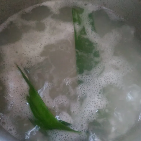 Cuci bersih beras kemudian campur dengan 800 ml air dan daun pandan.