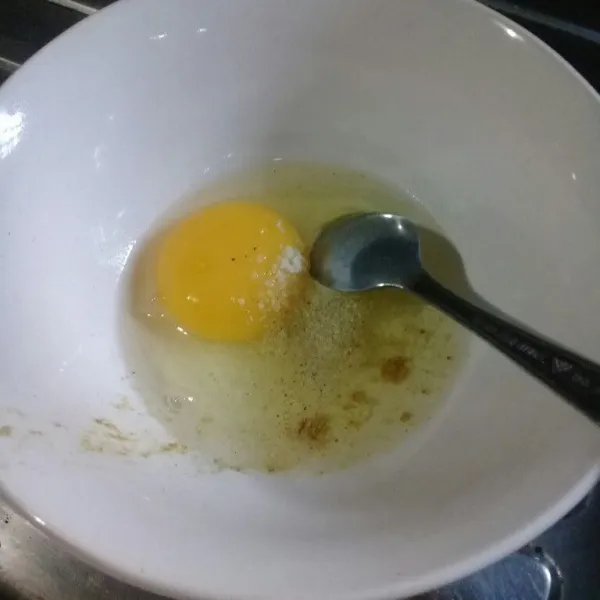 Pecahkan telur ke dalam mangkok, beri garam dan kaldu bubuk kemudian aduk rata.