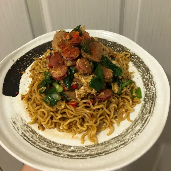 Tuang tumisan di atas Indomie Goreng. Sajikan.