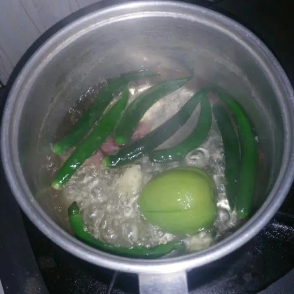 Siapkan panci, didihkan air lalu rebus cabe hijau, tomat, bawang merah dan bawang putih. Rebus sampai matang, tiriskan