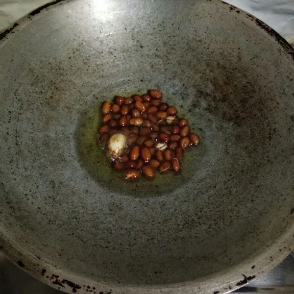 Panaskan minyak, goreng kacang tanah dan bawang putih hingga matang. Tiriskan