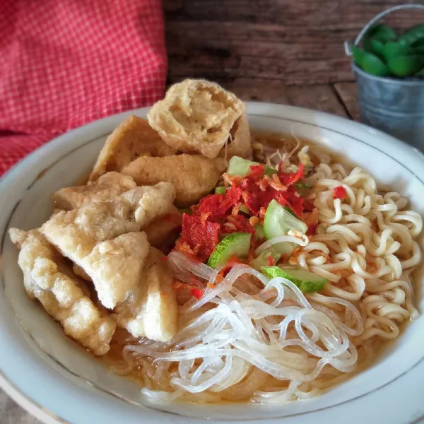 Untuk penyajian,  tata di mangkuk, mie, soun, taoge, pempek dan tahu. Beri irisan mentimun dan siram kuah rujak yang hangat