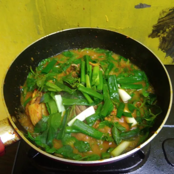 Setelah ayam matang masukkan cabai rawit, daun bawang dan kemangi. Masak hingga sedikit layu