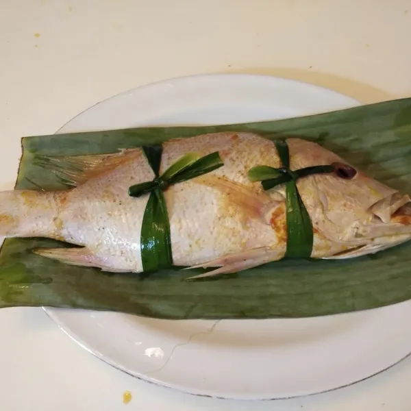 Ikat bagian badan ikan dengan daun pandan