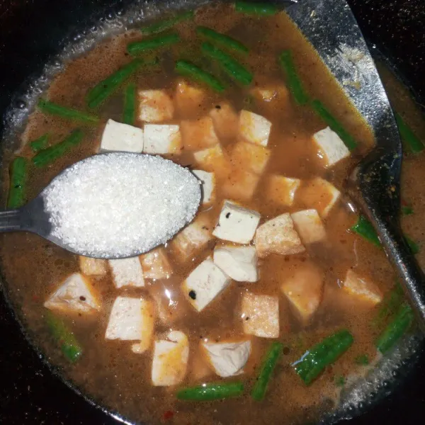 Tunggu sampai kacang panjang lunak kemudian masukkan tahu dan bumbui dengan garam, gula dan penyedap. Aduk rata tunggu sampai mendidih