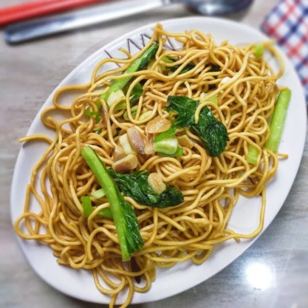 Bakmie goreng siap disajikan bersama dengan pecel sayur