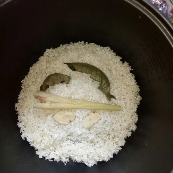 Cuci bersih beras, masukan ke panci rice cooker bersama salam dan serai