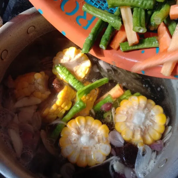 Masukkan jagung, kacang panjang dan wortel. Masak sampai agak empuk