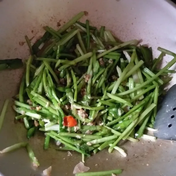 Panaskan minyak untuk menumis, kemudian tumis bumbu halus hingga harum. Masukkan oncom yang sudah dihancurkan, aduk merata dan beri sedikit air, tunggu hingga air mendidih, kemudian masukan daun genjer. Masak hingga daun layu, jangan lupa tambahkan garam dan gula secukupnya