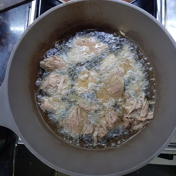 Setelah daging empuk, geprek masing-masing potongan daging dan masukkan dalam panci yang telah diisi air rebusan daging. Masukkan garam, penyedap rasa, dan asam jawa, lalu remas daging agar air keluar. Kemudian goreng dengan api sedang hingga agak kecoklatan, angkat