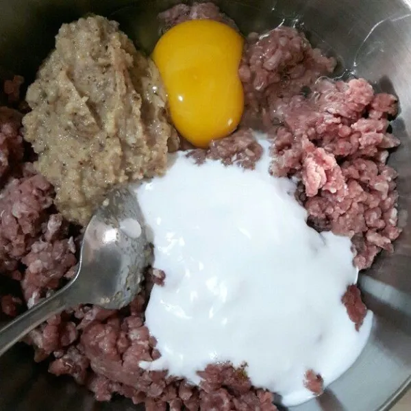 Dalam wadah tuang daging giling, telur, santan, dan bumbu halus