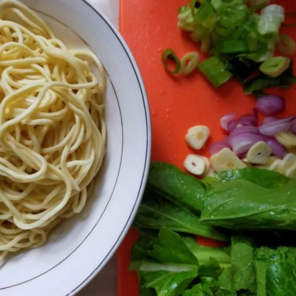 Siapkan bahan-bahan untuk membuat bakmi goreng. Rebus mie telur hingga matang. Cuci bersih sawi hijau. Iris bawang merah dan bawang putih