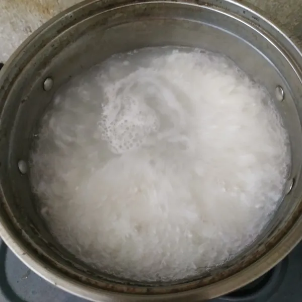 Didihkan air, masukkan beras yang sudah dicuci bersih. Masak sampai beras setengah matang