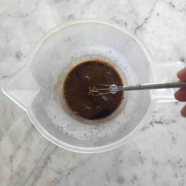 Siapkan wadah, masukkan bubuk kopi instan, gula pasir, gula merah, dan air panas. Aduk rata hingga semua larut.