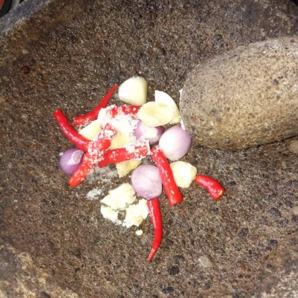 Siapkan cobek, haluskan bawang merah, bawang putih, kemiri, cabe merah dan garam. Ulek sampai halus.